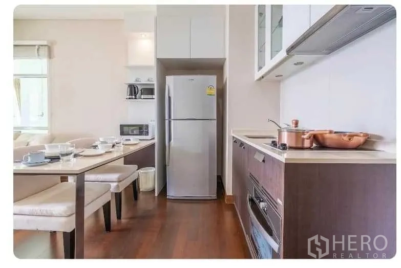 公寓 出售在Watthana, Bangkok - 走廊式现代厨房，内置烤箱、灶台与储物柜