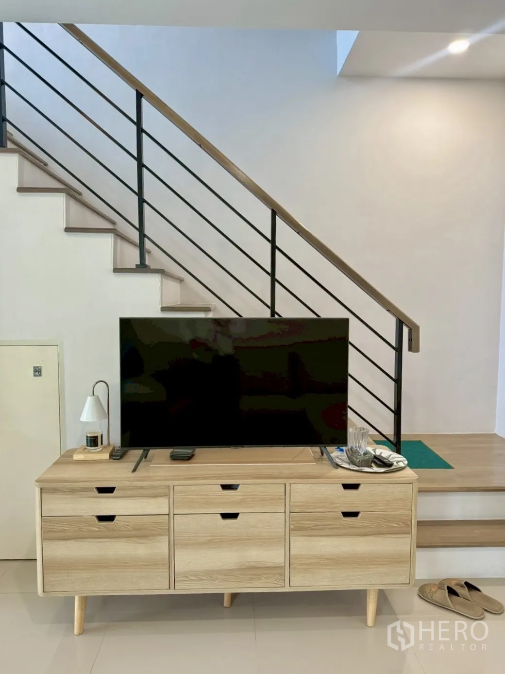 联排别墅 for rent in Prawet, Bangkok - 室内木质电视柜与金属扶手楼梯。
