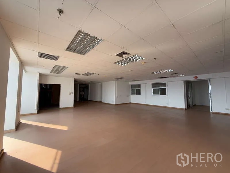 办公空间 出租在Chatuchak, Bangkok - 大型空置办公楼层，吊顶送风口、日光灯与双入口门。