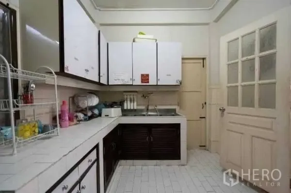 บ้าน ให้เช่าในKhlong Toei, Bangkok - ห้องครัวใช้งานสะดวก เคาน์เตอร์กระเบื้องสีขาว ตู้แขวน และอ่างล้างจานสแตนเลส