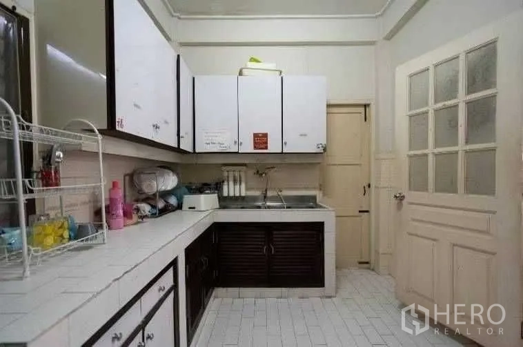 บ้าน ให้เช่าในKhlong Toei, Bangkok - ห้องครัวใช้งานสะดวก เคาน์เตอร์กระเบื้องสีขาว ตู้แขวน และอ่างล้างจานสแตนเลส