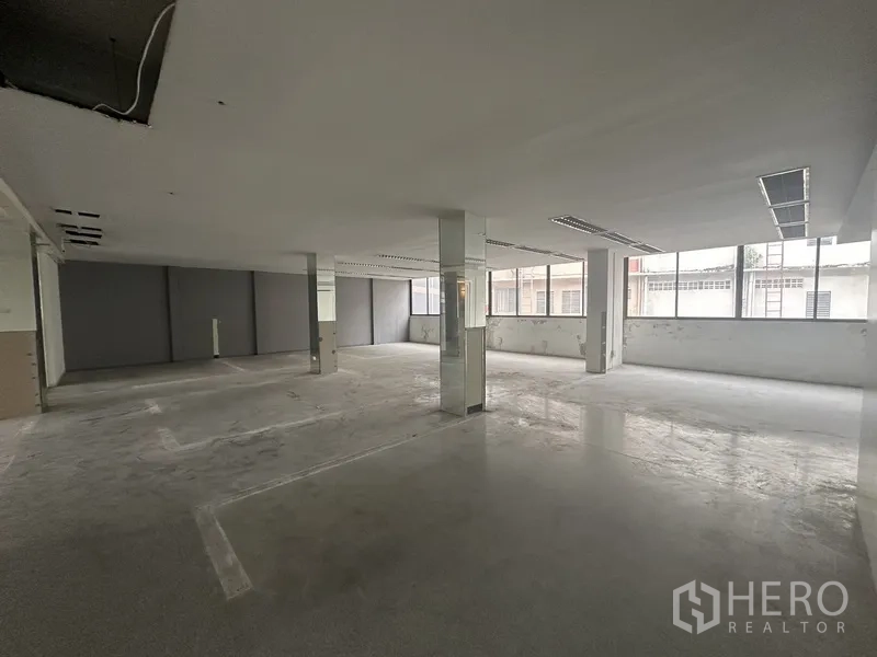 Office Space for rent in Khlong Toei, Bangkok - Open workspace with central columns, large windows and polished concrete floor.