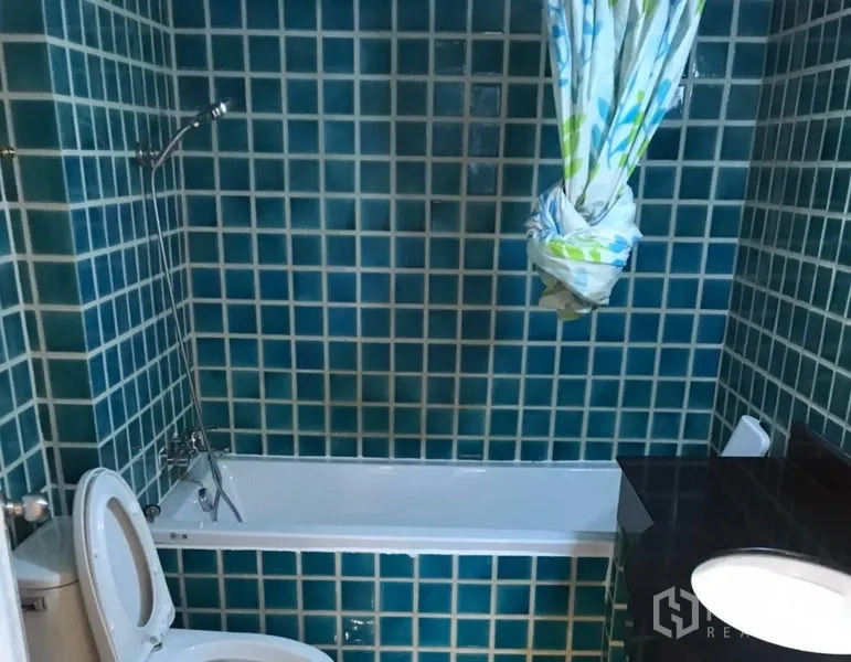 Condominium for rent in Watthana, Bangkok - Bathroom with teal mosaic tiles, bathtub and handheld shower.