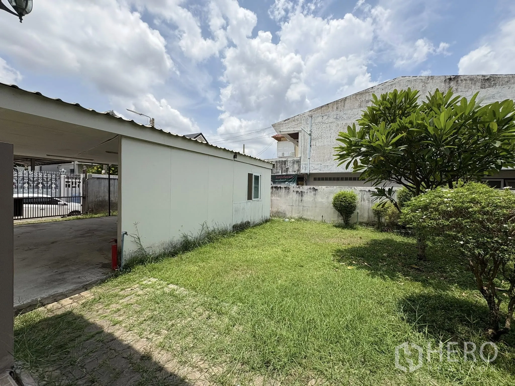 บ้าน ขายในPhra Khanong, Bangkok - ลานหญ้าข้างบ้าน กำแพงอาคารสีขาวและพุ่มไม้