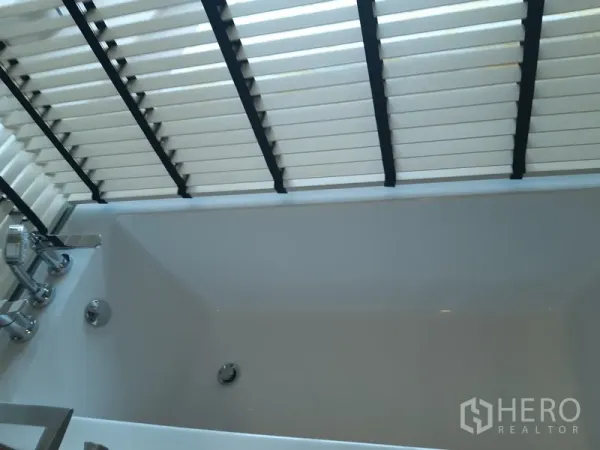 公寓 出租或出售在Watthana, Bangkok - 靠窗的深浴缸，配百叶遮挡。