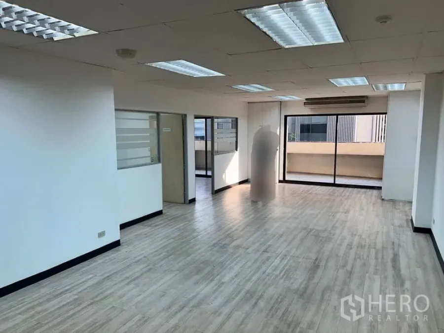 办公空间 出租在Pathum Wan, Bangkok - 明亮的开放式办公室，木纹地板，吊顶灯，落地推拉玻璃门通往阳台。