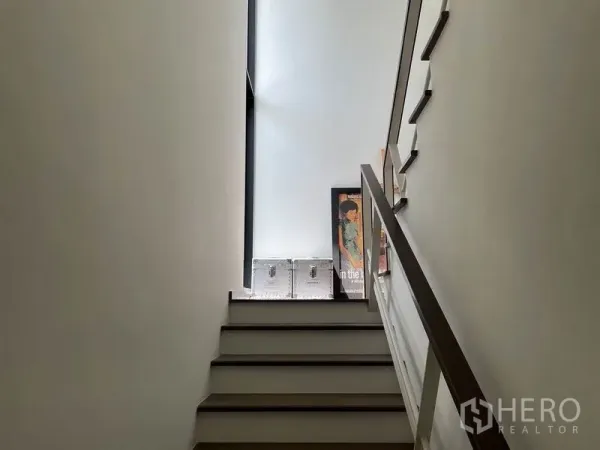 บ้าน ขายในSai Mai, Bangkok - โถงบันไดสว่างด้วยช่องแสงสูง ผนังสีขาว และราวไม้