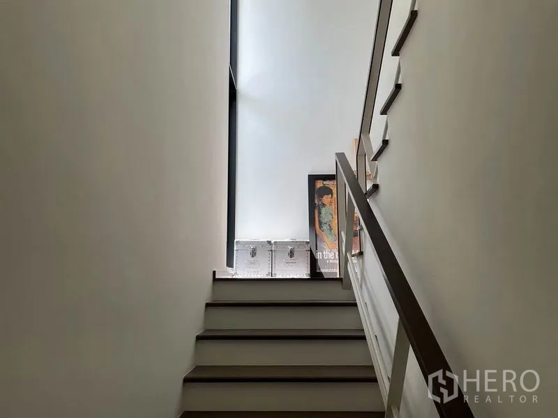 บ้าน ขายในSai Mai, Bangkok - โถงบันไดสว่างด้วยช่องแสงสูง ผนังสีขาว และราวไม้