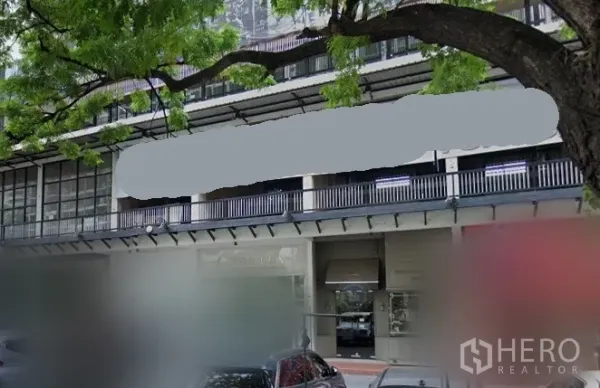 零售空间 出租在Khlong Toei, Bangkok - 曼谷空堤区临街商铺外观，整面玻璃门面、带顶人行道与绿荫大树