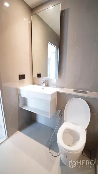 คอนโด ขายในKhlong Toei, Bangkok - อีกมุมของห้องน้ำที่มีบานกระจกสูง อ่างล้างหน้า และโถสุขภัณฑ์ข้างพื้นที่อาบน้ำ