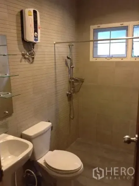 Detached House for rent in Ratchathewi, Bangkok - Modern bathroom with walk-in shower, wall-mounted water heater, toilet and small window.