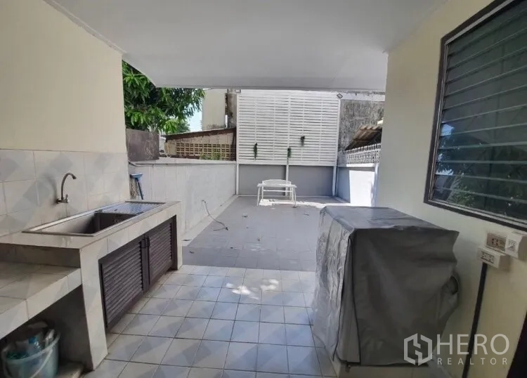 Townhouse for rent in Watthana, Bangkok - Covered Thai-style kitchen and utility area opening to a private patio.