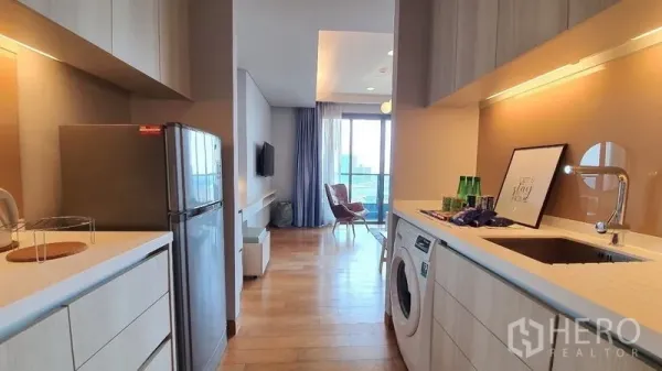 คอนโด ให้เช่าในKhlong Toei, Bangkok - ครัวแบบแกลเล่ย์สว่างพร้อมตู้บิวท์อิน อ่างล้างจาน และเครื่องซักผ้า เชื่อมต่อไปยังห้องนั่งเล่นและระเบียง