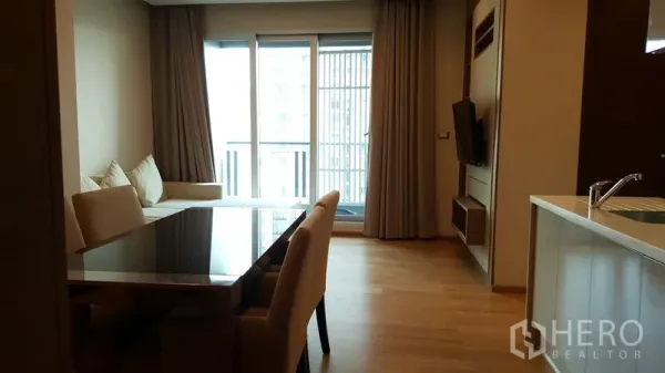 คอนโด ให้เช่าในRatchathewi, Bangkok - พื้นที่นั่งเล่นและรับประทานอาหารแบบเปิดพร้อมประตูระเบียง ผนังบิลท์อินทีวี และผ้าม่านสูงจรดเพดาน