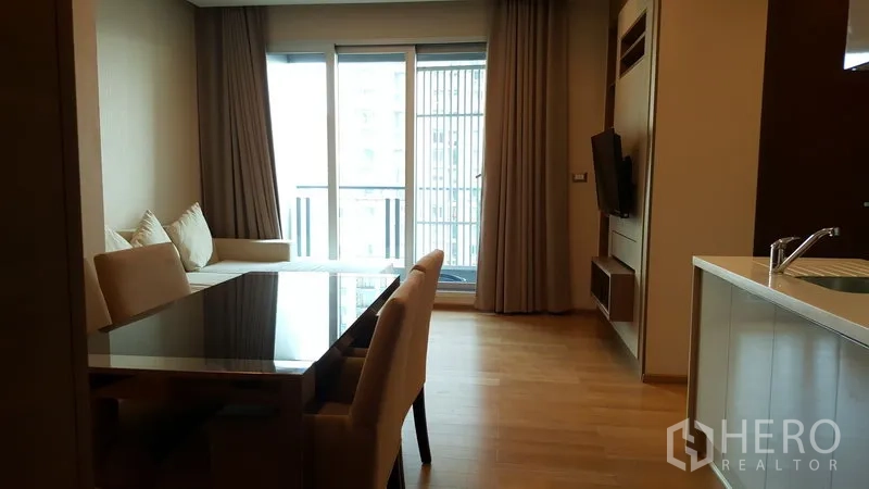 คอนโด ให้เช่าในRatchathewi, Bangkok - พื้นที่นั่งเล่นและรับประทานอาหารแบบเปิดพร้อมประตูระเบียง ผนังบิลท์อินทีวี และผ้าม่านสูงจรดเพดาน