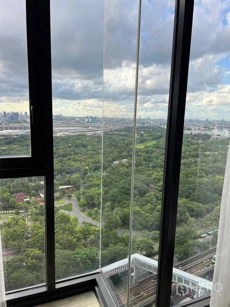 公寓 出租在Chatuchak, Bangkok - 窗外全景，郁郁葱葱的公园、城市天际线与轨道线。