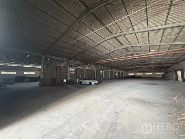 Warehouse for rent in Khlong Toei, Bangkok - Expansive warehouse interior with high steel roof, concrete floor and central columns.