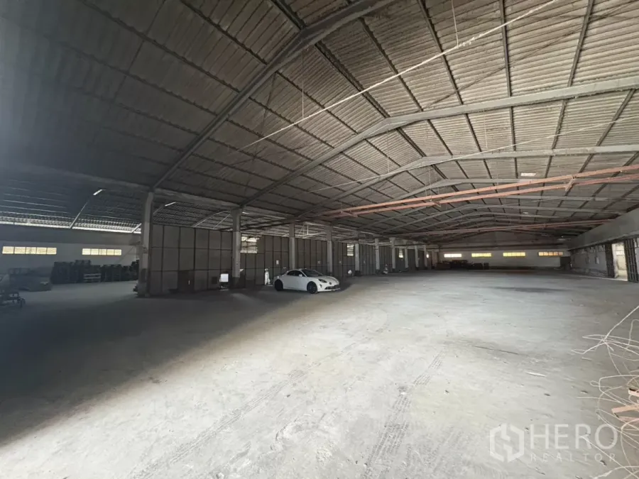 Warehouse for rent in Khlong Toei, Bangkok - Expansive warehouse interior with high steel roof, concrete floor and central columns.