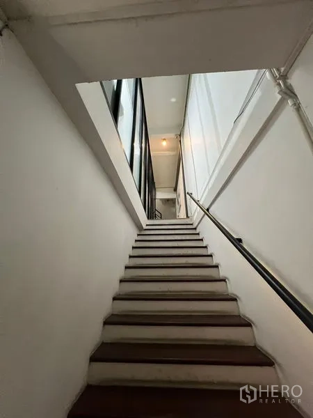 零售空间 出租在Watthana, Bangkok - 室内楼梯通往上层，白色墙面与扶手。