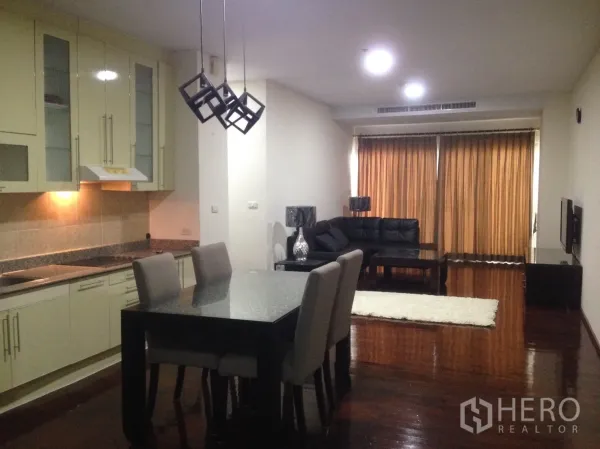 คอนโด ให้เช่าในWatthana, Bangkok - พื้นที่นั่งเล่นและทานอาหารแบบเปิดโล่ง พร้อมครัวบิลท์อิน โคมไฟ และโซฟาหนังสีดำ