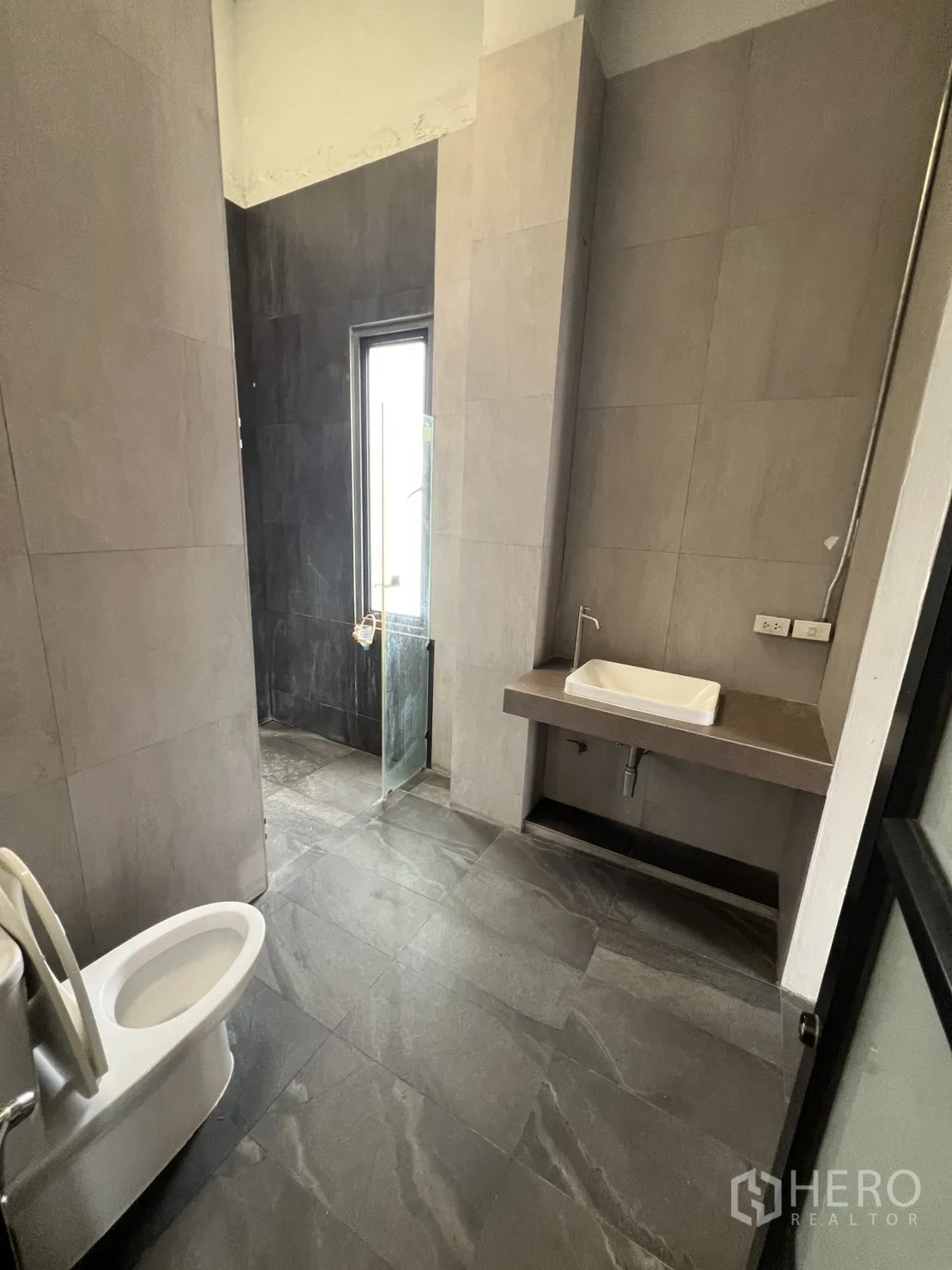 Home Office for rent in Mueang Nonthaburi, Nonthaburi - Modern bathroom with grey tiles, shower enclosure and toilet.