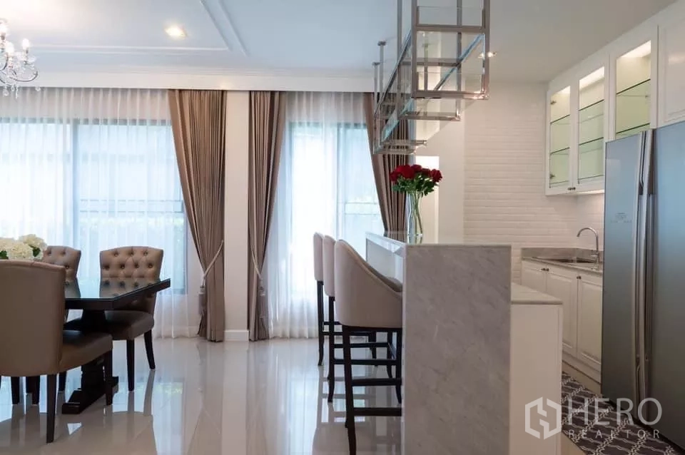 บ้าน ให้เช่าในPrawet, Bangkok - ครัวสว่างพร้อมเคาน์เตอร์บาร์ เก้าอี้สูง ตู้กระจก และตู้เย็นสองประตู