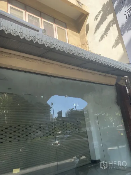พื้นที่ขายปลีก ให้เช่าในWatthana, Bangkok - ด้านหน้าร้านค้าชั้นล่าง กระจกเต็มบาน มี กันสาดโลหะและประตูลูกกรงภายใน บริเวณสุขุมวิท