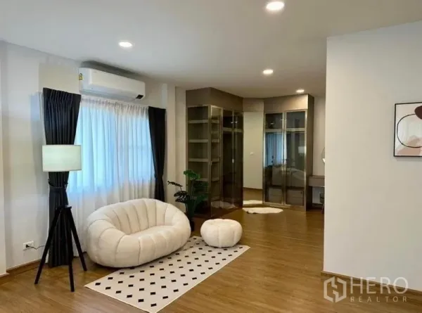 Detached House for rent in Bang Phli, Samut Prakan - Walk-in closet zone with glass wardrobes, lounge chair and warm wood flooring.