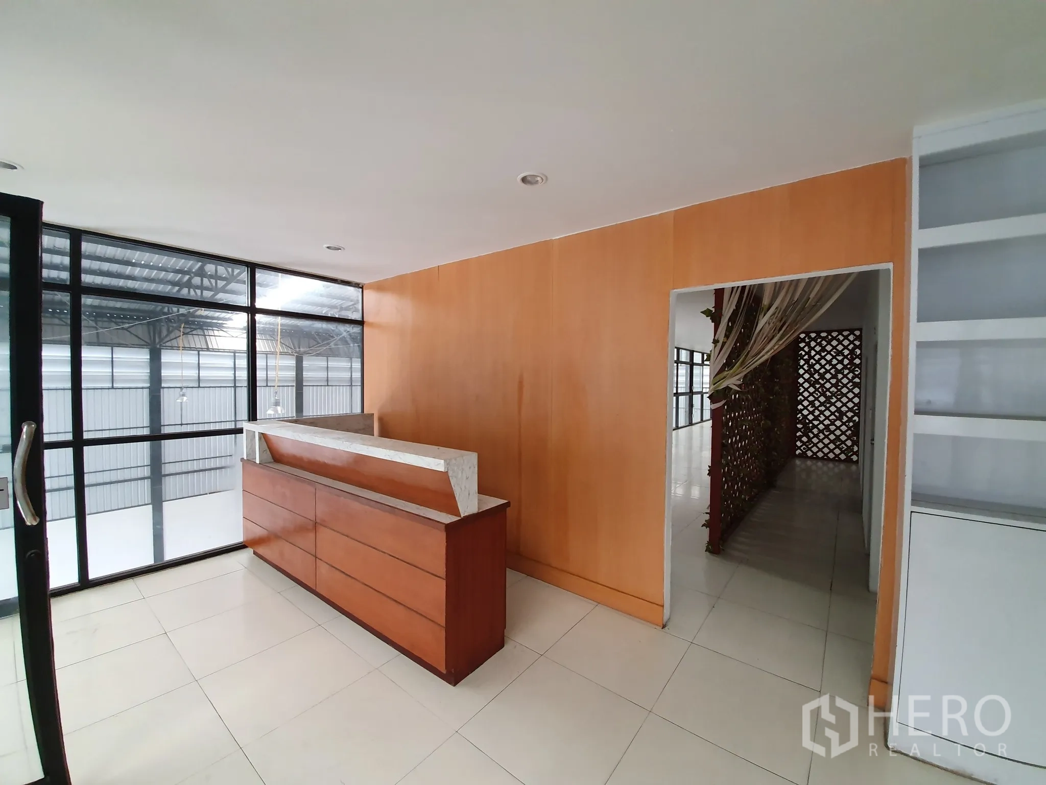 货栈 出租在Bang Khen, Bangkok - 带木饰面墙的接待区，玻璃隔断可眺望仓库。