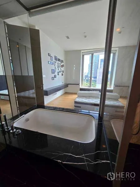 公寓 出租或出售在Bang Rak, Bangkok - 大理石包裹的浴缸，通过玻璃隔断与卧室相连，带城市景观。