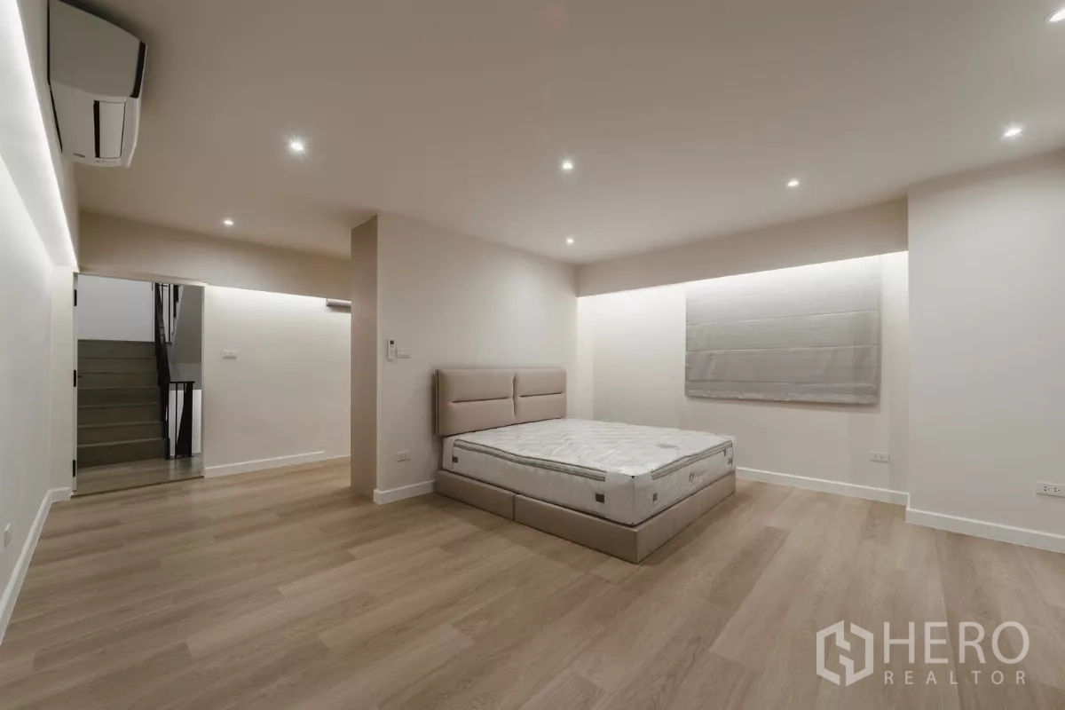 联排别墅 出租在Watthana, Bangkok - 宽敞卧室，平台床、遮光帘与灯带。