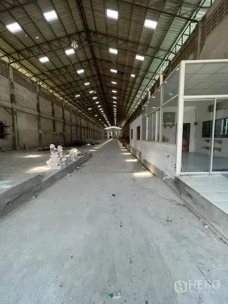 Warehouse for rent in Phra Samut Chedi, Samut Prakan - Warehouse drive-through lane with glass office room and loading areas.