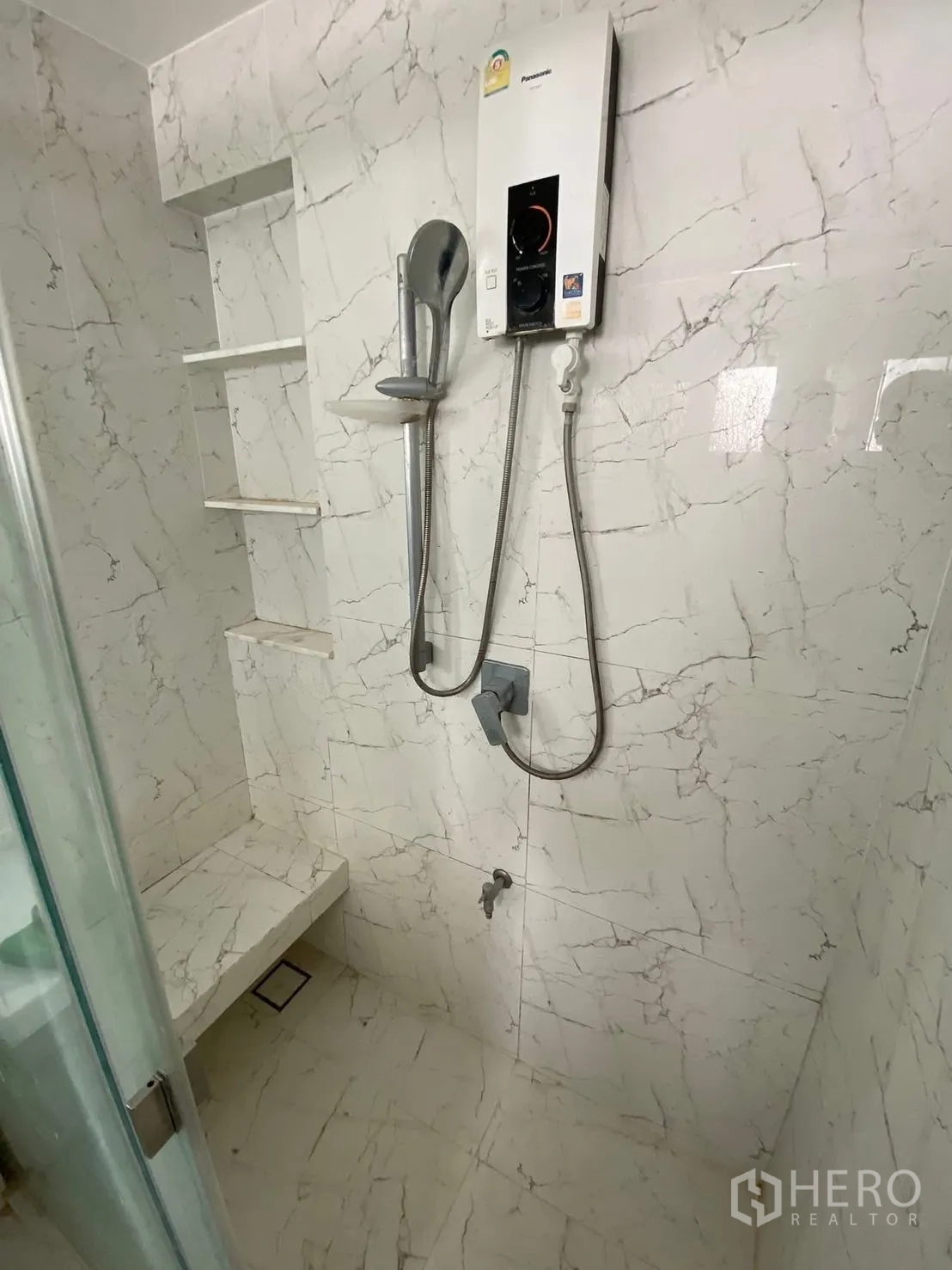 บ้าน ให้เช่าในPrawet, Bangkok - มุมใกล้ชิดของพื้นที่อาบน้ำ กระเบื้องลายหินอ่อน เครื่องทำน้ำอุ่น และที่นั่ง