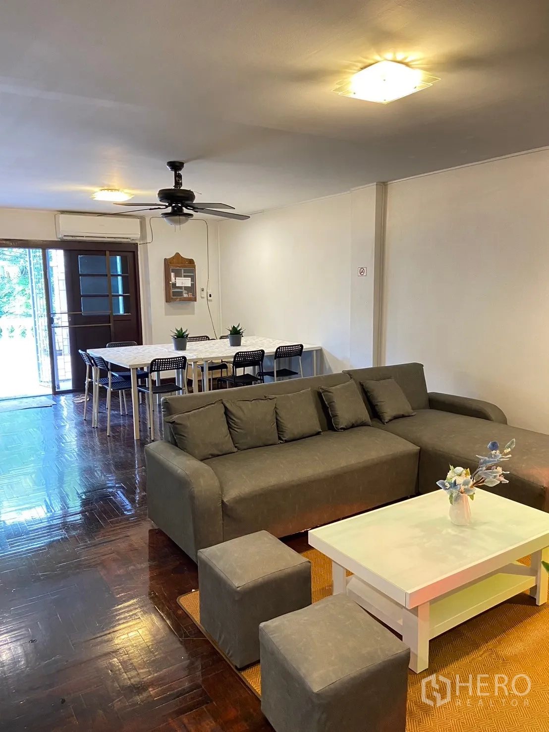 Home Office for rent in Watthana, Bangkok - Living area with sectional sofa, coffee table, dining set and ceiling fan.