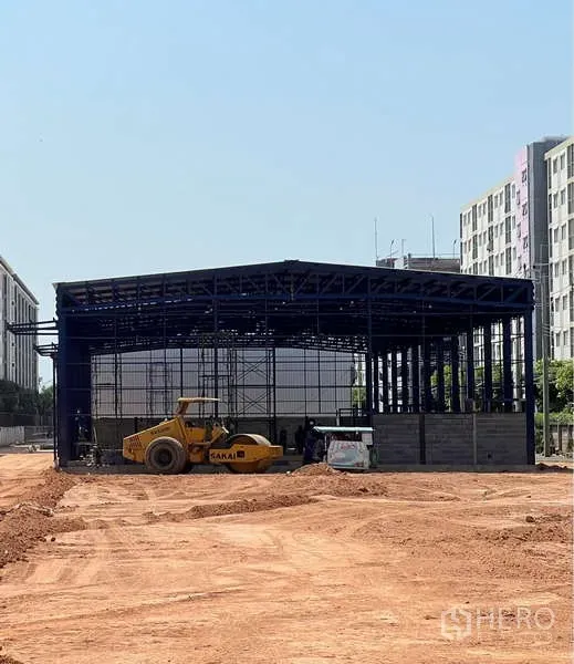 คลังสินค้า ให้เช่าในLat Krabang, Bangkok - โครงสร้างเหล็กโกดังระหว่างก่อสร้าง มีรถบดถนนบนลานดิน ย่านลาดกระบัง