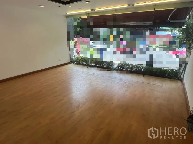 零售空间 出租在Pathum Wan, Bangkok - 店内面向街景，落地玻璃窗与外侧绿植带。