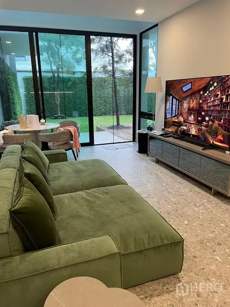Detached House for sale in Saphan Sung, Bangkok - Cozy lounge opening to a private garden through full-height sliding doors.