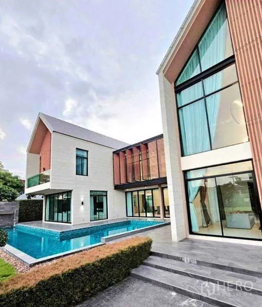 บ้าน ขายในKhlong Sam Wa, Bangkok - ภายนอกบ้านสองชั้นสไตล์โมเดิร์น สระว่ายน้ำล้อมรอบ และกระจกบานใหญ่
