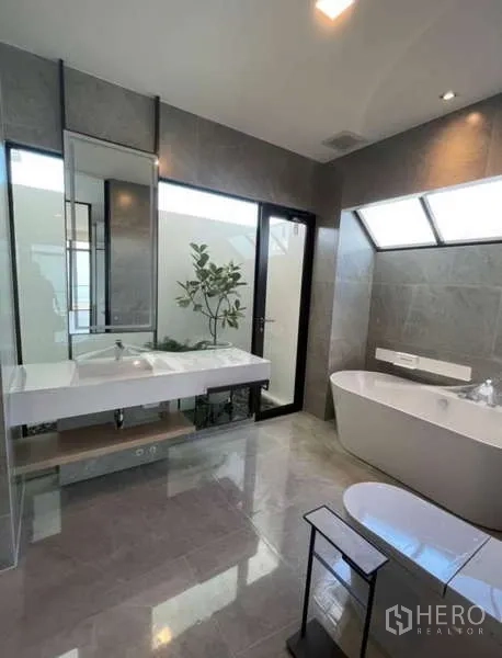 Detached House for rent in Samut Prakan - Spa-style bathroom with freestanding tub, wide vanity and skylight.
