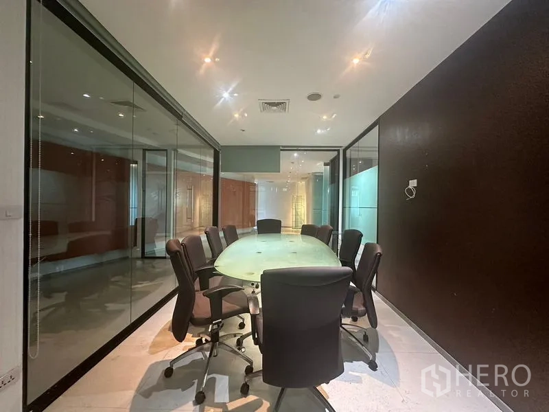 Office Space for rent in Khlong Toei, Bangkok - Glass-walled conference room with oval table and swivel chairs.