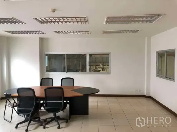工厂 出租在Bang Sao Thong, Samut Prakan - 明亮会议室，圆形会议桌，可俯瞰生产区。
