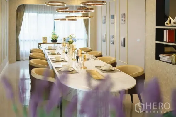 Detached House for rent or sale in Bang Phli, Samut Prakan - Elegant dining room with a long marble table, gold ring pendant lights and floor-to-ceiling curtains.
