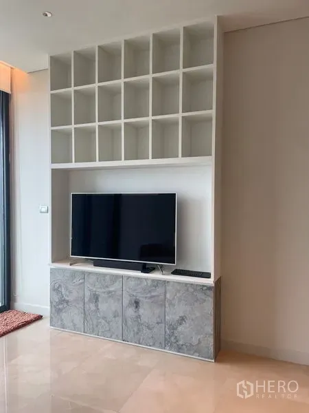 คอนโด ให้เช่าในPathum Wan, Bangkok - ผนังทีวีบิวท์อินพร้อมชั้นโชว์แบบช่องๆ และตู้ล่างลายหินอ่อน