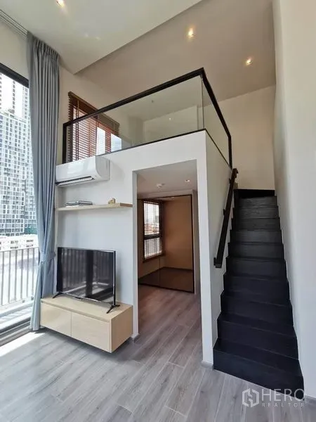 คอนโด ให้เช่าในPhaya Thai, Bangkok - บันไดขึ้นชั้นลอยเหนือชั้นวางทีวี พร้อมประตูกระจกสู่ระเบียงและเพดานสูง