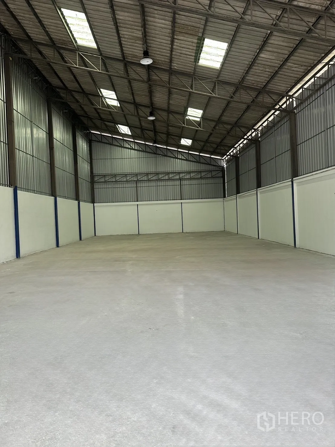 仓库 for rent in Mueang Samut Prakan, Samut Prakan - 仓库内部通透空间，高人字顶与采光板，混凝土地面。