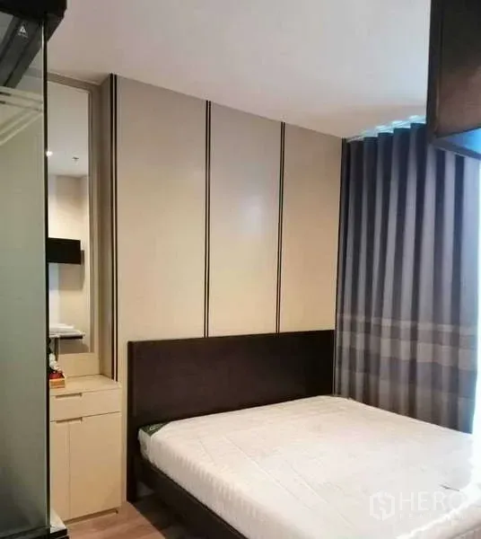 Condominium for rent or sale - Master bedroom with built-in wardrobe, upholstered headboard and blackout curtains.