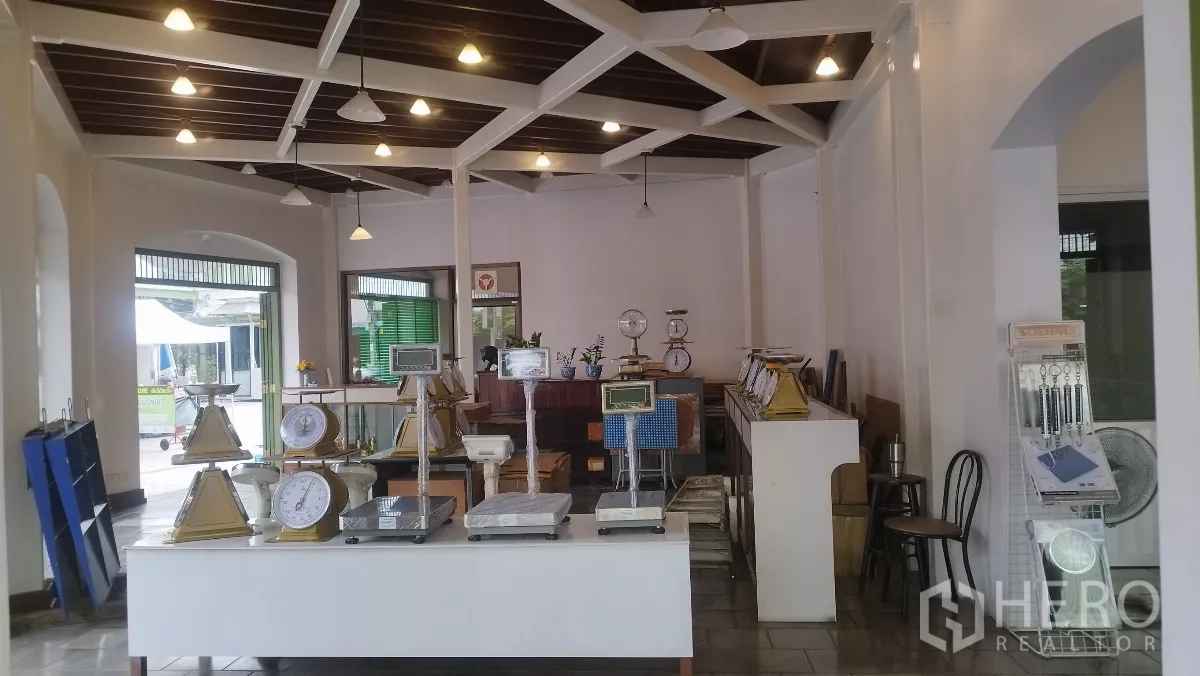 零售空间 出租在Bangkok - 开放式展售空间，挑高木梁天花与吊灯，地砖铺设。