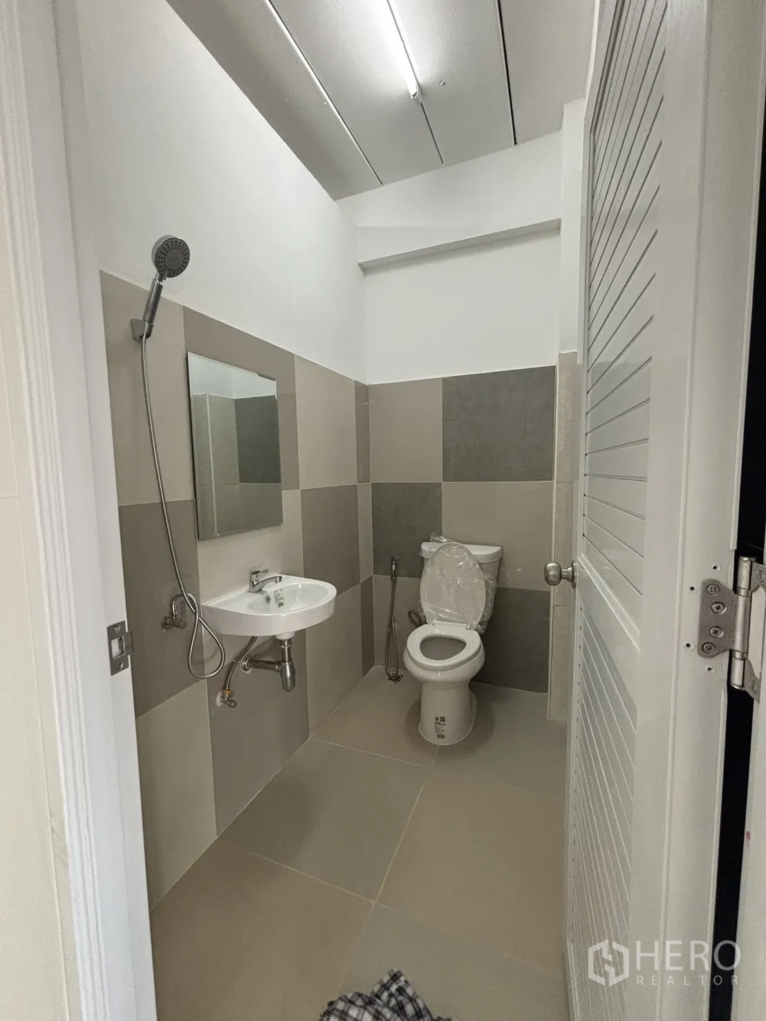 Home Office for rent in Phra Khanong, Bangkok - Clean tiled bathroom with shower, sink and toilet.