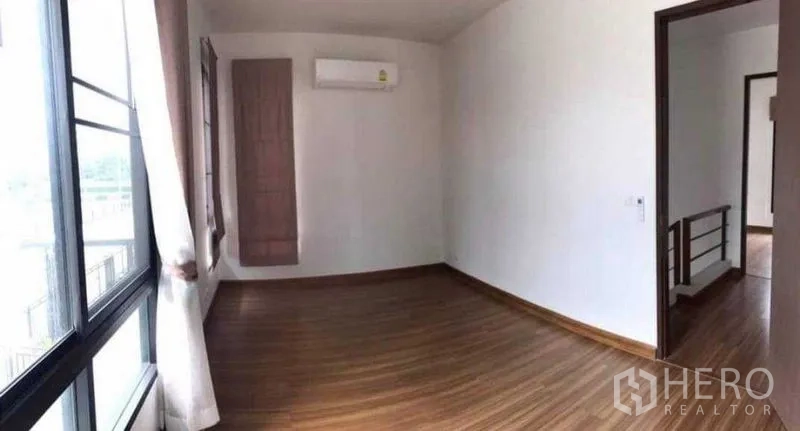 Detached House for rent or sale in Thanyaburi, Pathum Thani - Upstairs multipurpose room with wood flooring, air conditioner and wide windows.