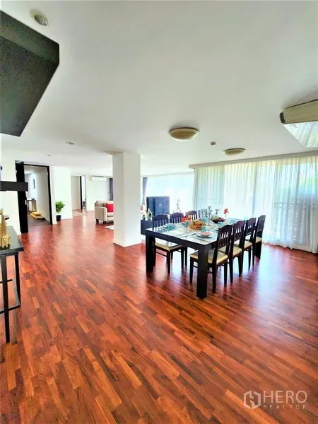 公寓 出租在Bang Rak, Bangkok - 明亮餐区，六人餐桌临大窗与木地板。